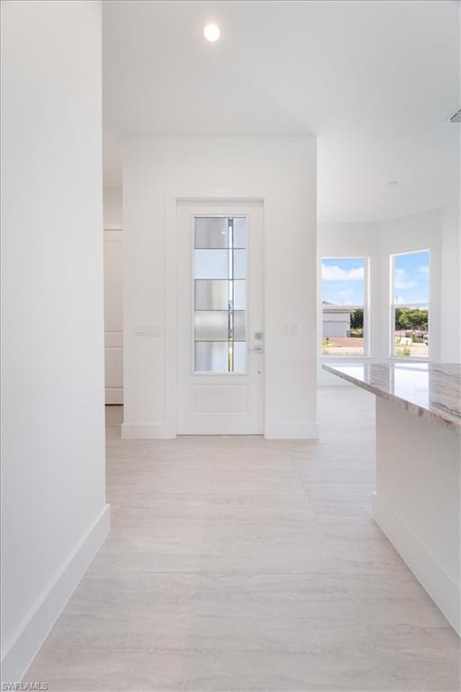 Hall featuring baseboards, recessed lighting, and light wood-style flooring