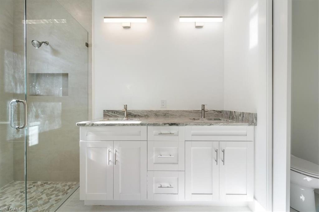 Bathroom with a sink, a shower stall, and toilet