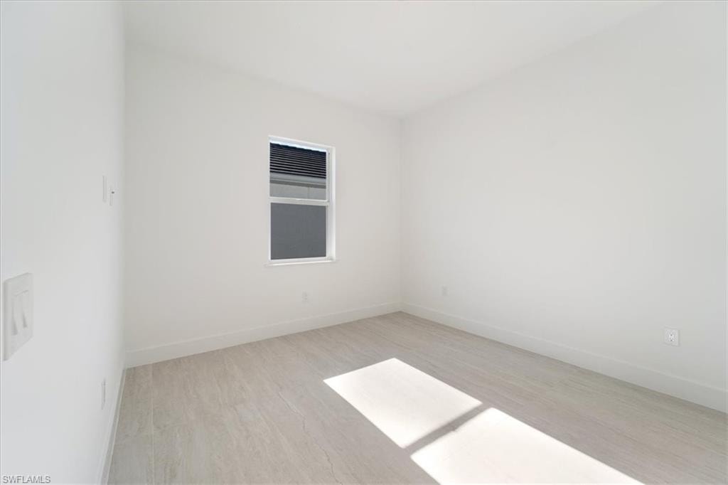Spare room featuring baseboards and wood finished floors