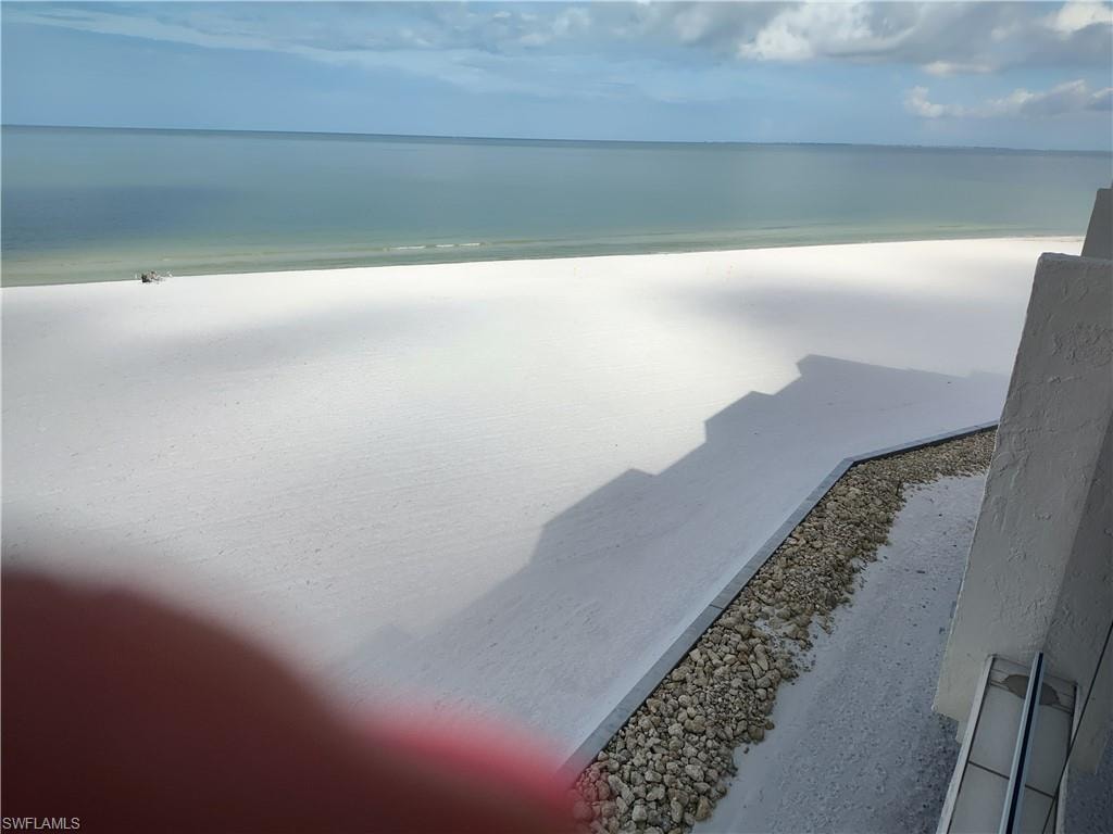 Balcony featuring view of water and beach