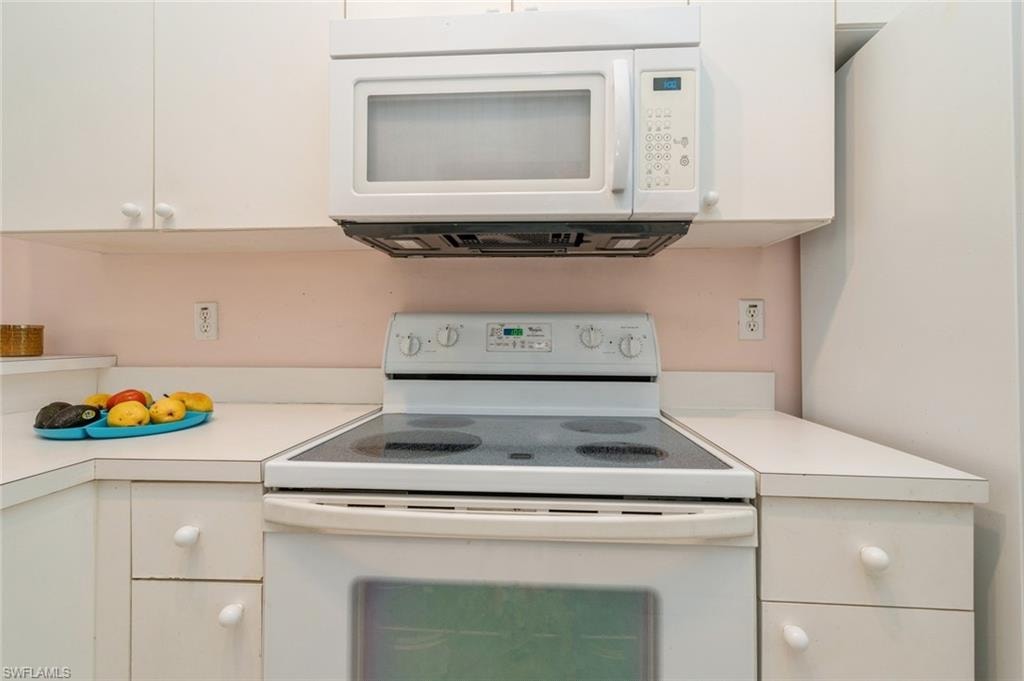 Kitchen featuring white cabinets and white appliances