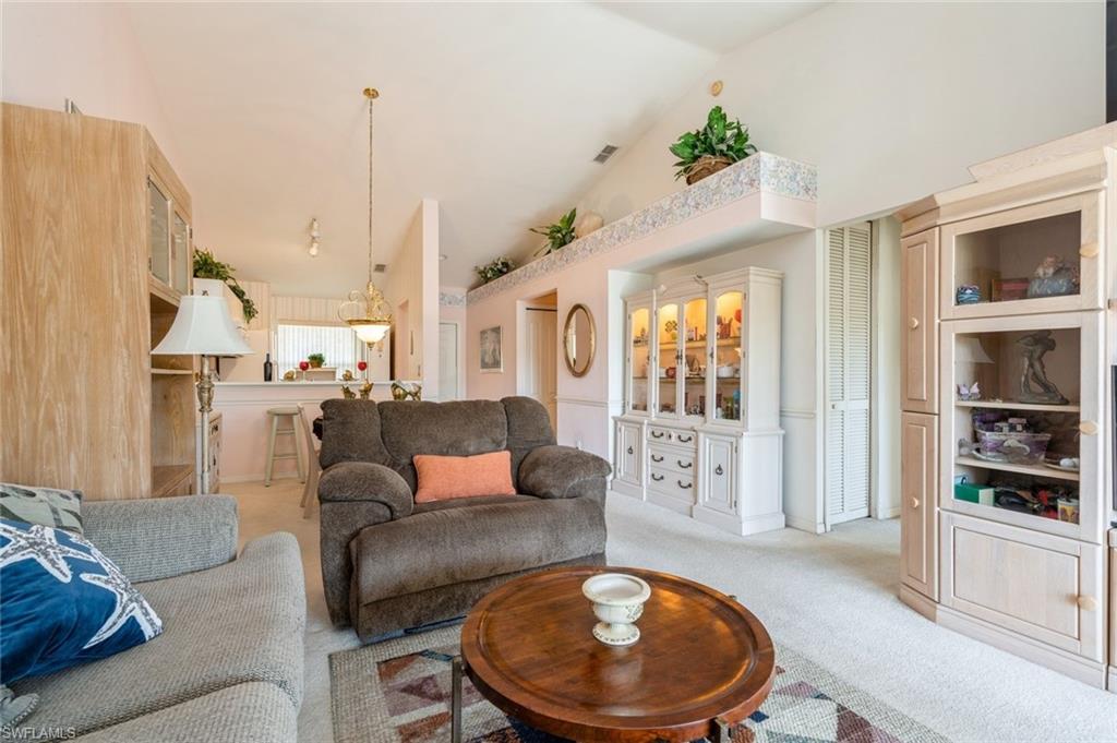 Living room with light carpet and vaulted ceiling