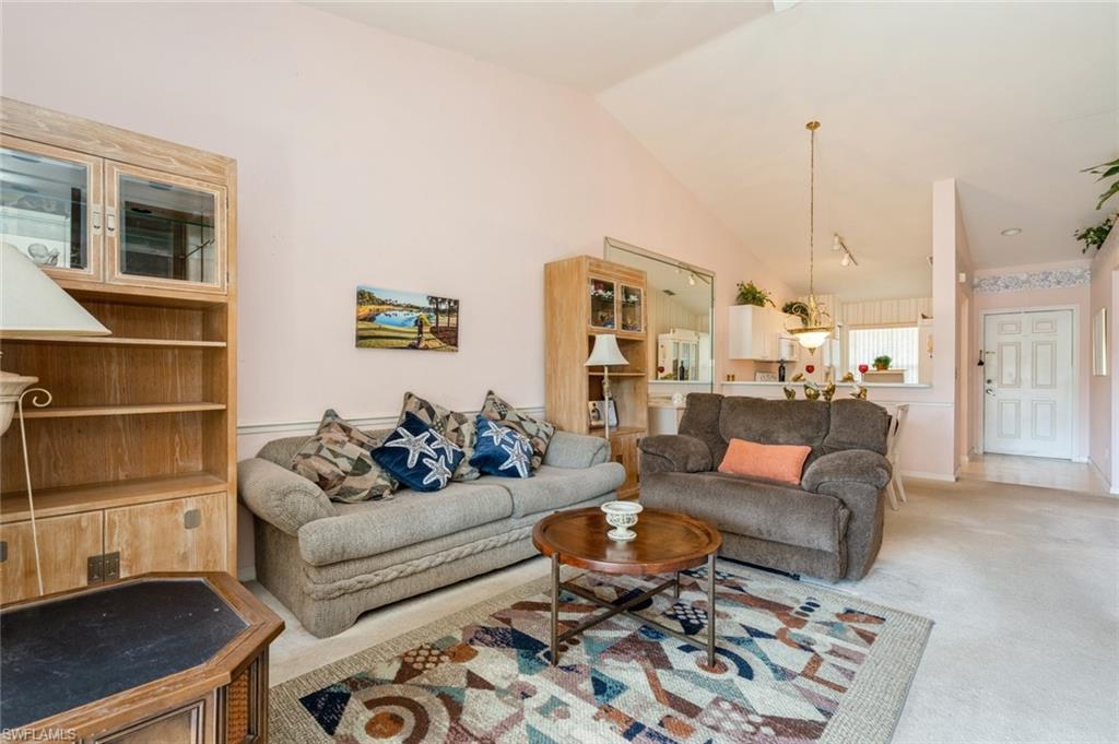 Carpeted living room featuring lofted ceiling
