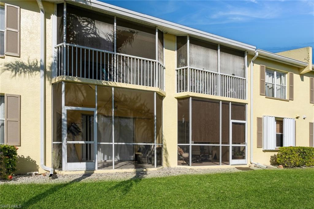 Back of property featuring a lawn