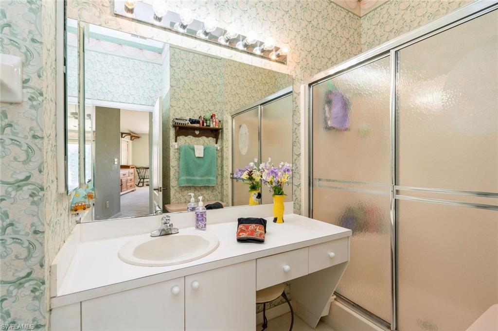 Bathroom with vanity and a shower with door
