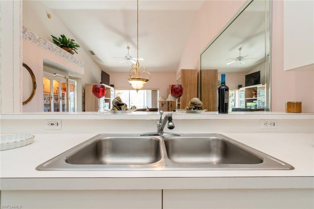 Room details with white cabinets, decorative light fixtures, and sink