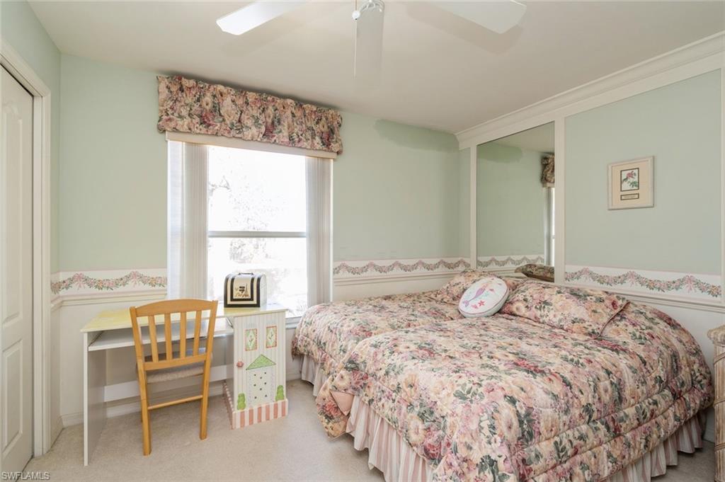 Carpeted bedroom featuring ceiling fan and ornamental molding