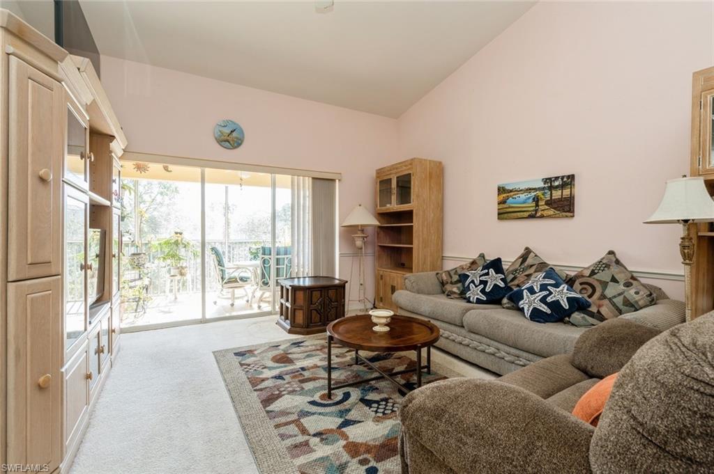 Living room featuring light colored carpet and high vaulted ceiling