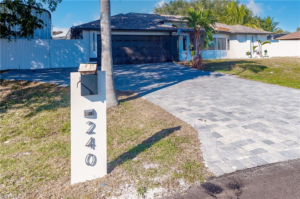 View of front of home with a garage and a front lawn