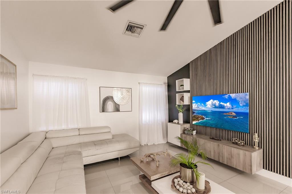 Living room with vaulted ceiling and light tile patterned flooring