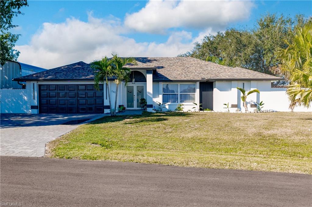 Ranch-style home with french doors, a front lawn, and a garage