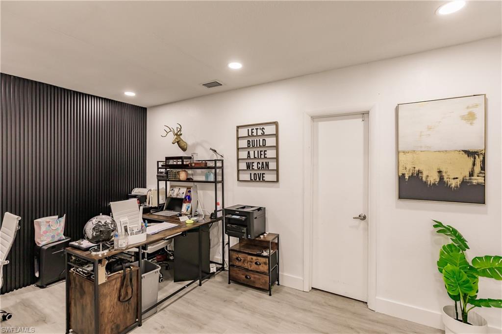 Home office with light hardwood / wood-style flooring