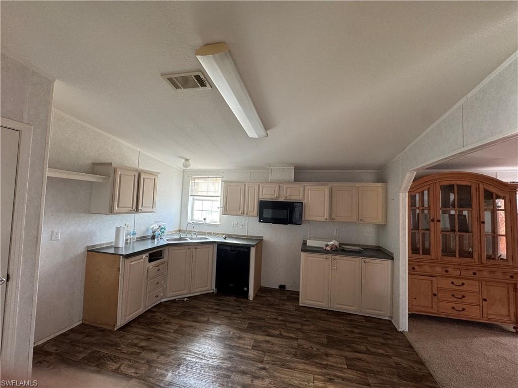 Kitchen with dark wood-type flooring, black appliances, vaulted ceiling, and sink