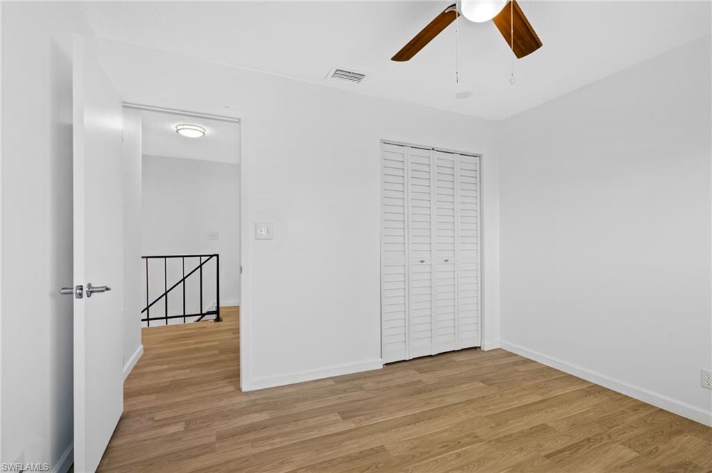 Unfurnished bedroom with ceiling fan, a closet, and light LVP wood-style floors
