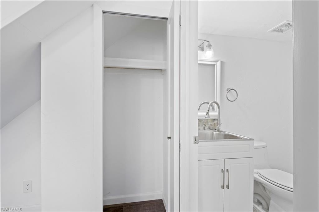 Bathroom featuring vanity, LVP wood-style floors, and toilet. First Floor Bathroom