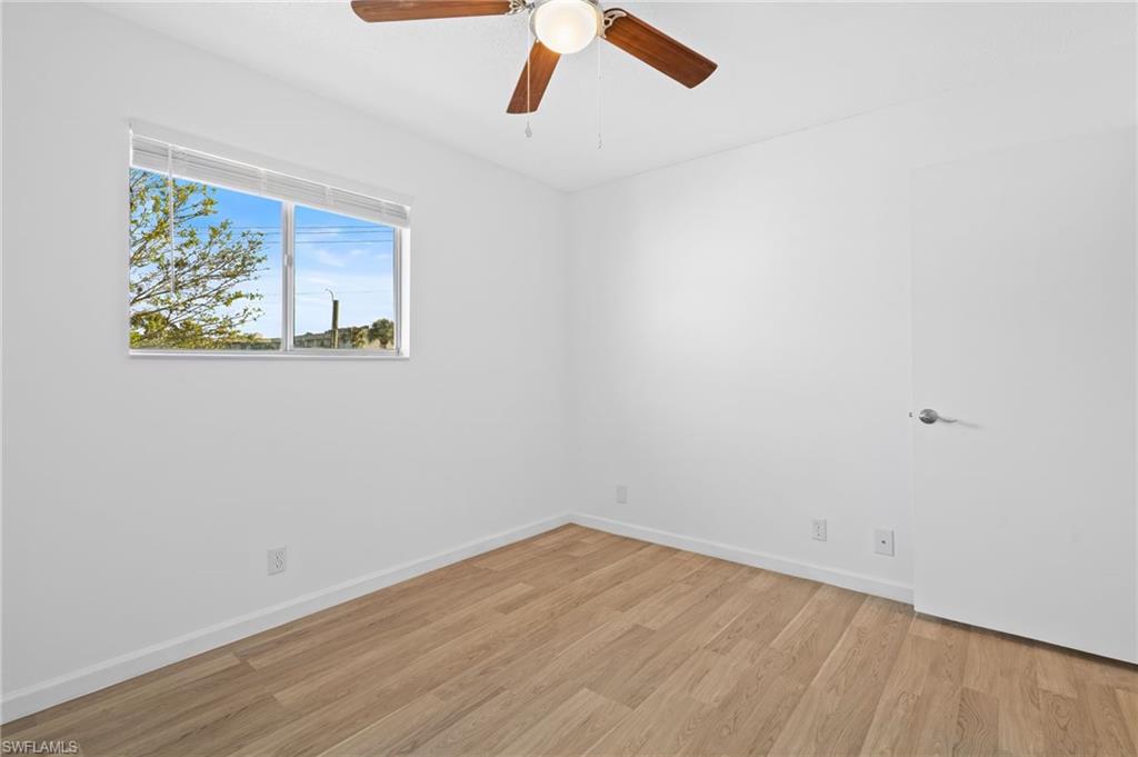 Empty room with ceiling fan and light wood-type flooring