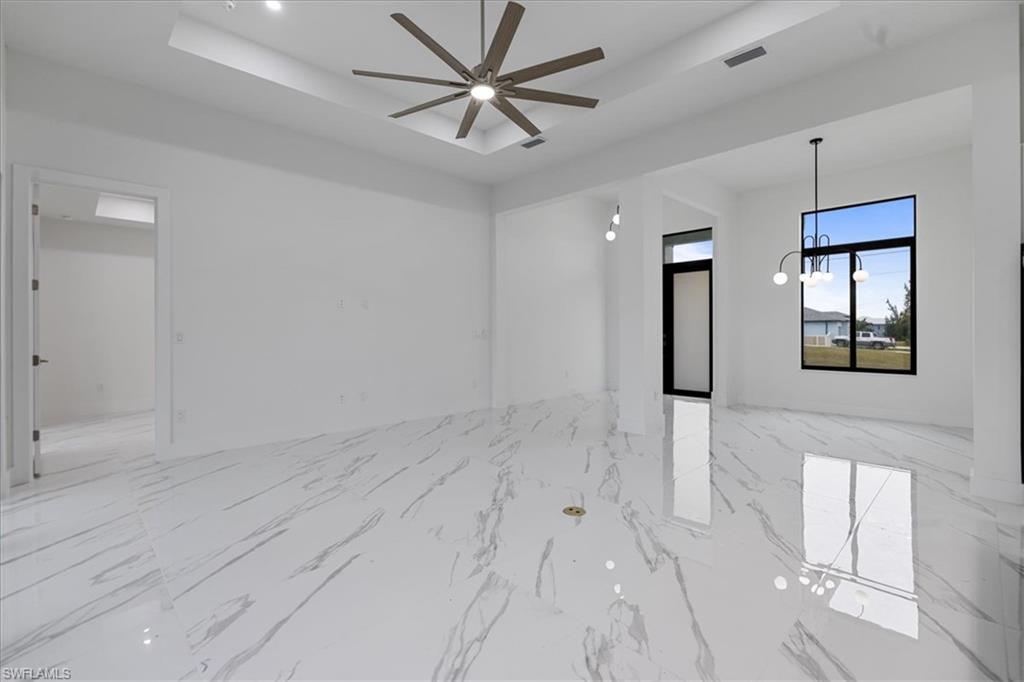 Spare room featuring a tray ceiling and ceiling fan