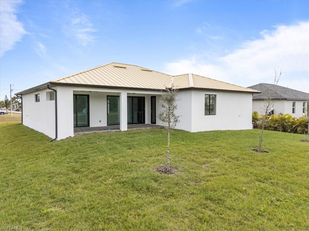 Rear view of property featuring a yard and a patio