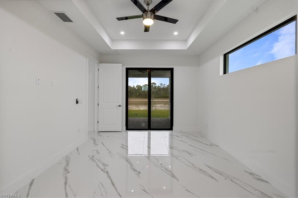 Spare room featuring ceiling fan and a tray ceiling