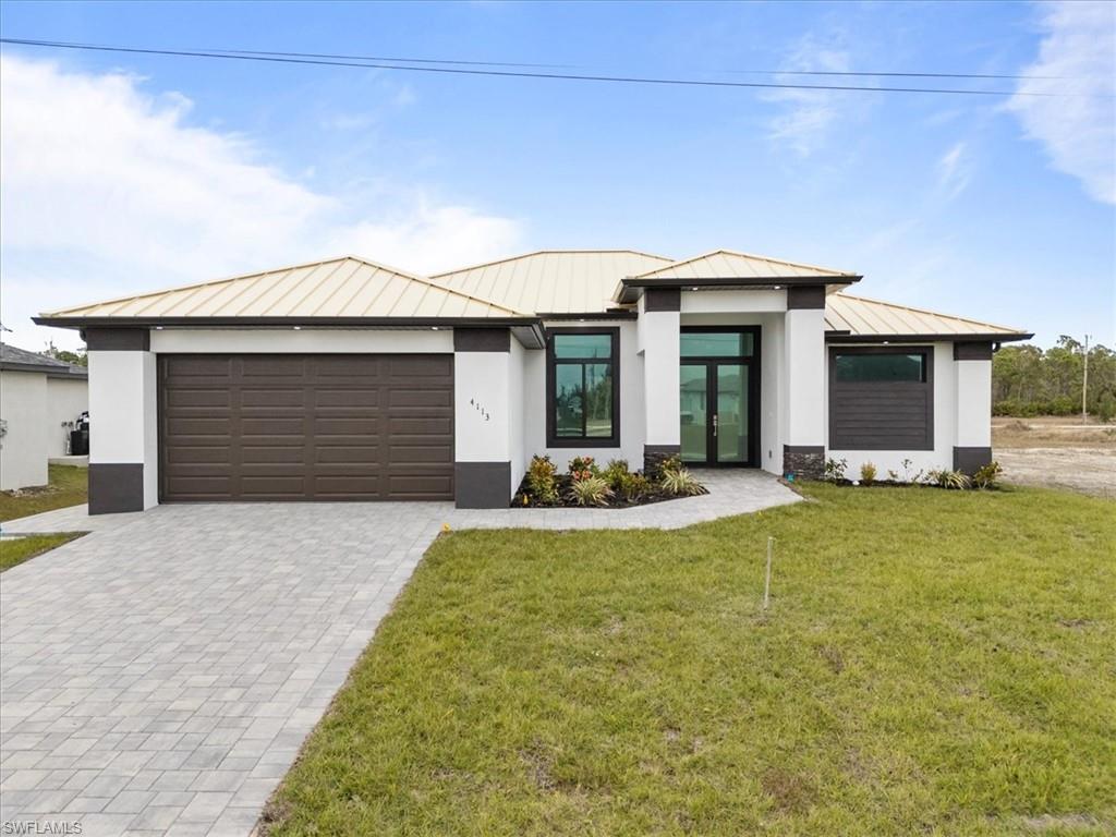 View of front of home with a front lawn and a garage