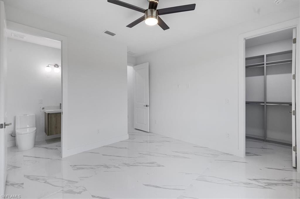 Unfurnished bedroom featuring connected bathroom and ceiling fan