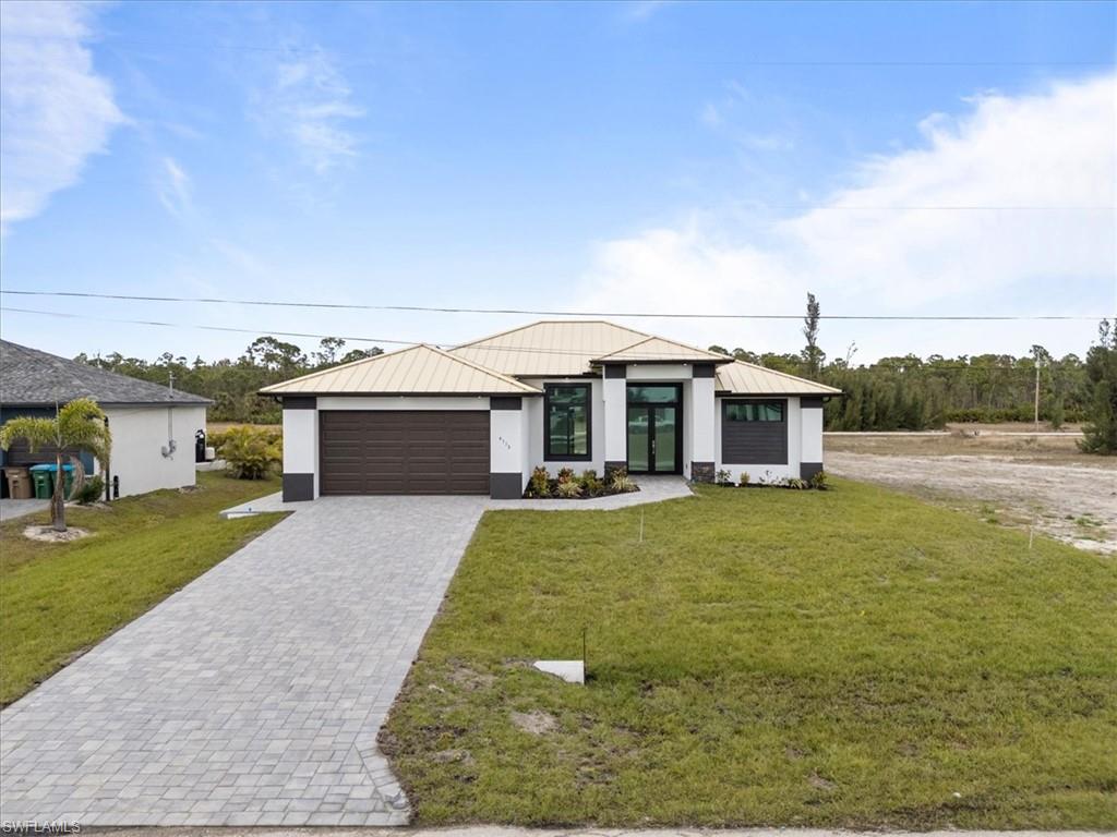 View of front of property featuring a front lawn and a garage