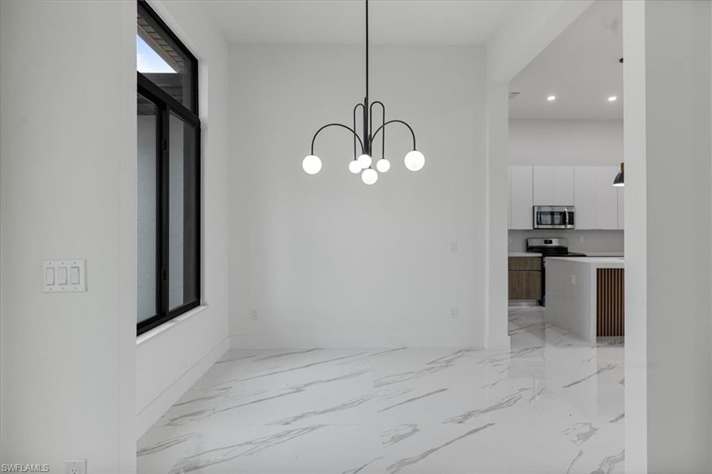 Unfurnished dining area featuring a chandelier