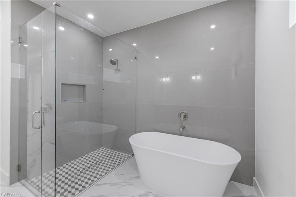 Bathroom with separate shower and tub and tile walls