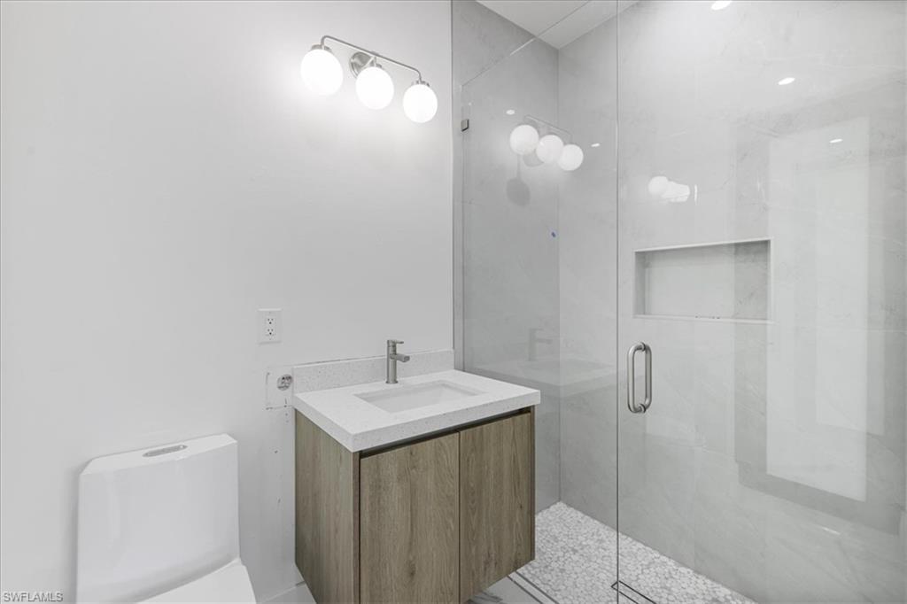 Bathroom featuring vanity, toilet, and walk in shower