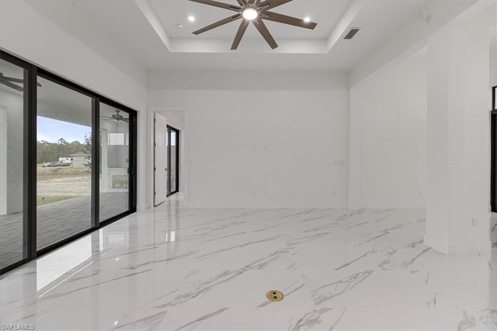 Spare room featuring a tray ceiling and ceiling fan