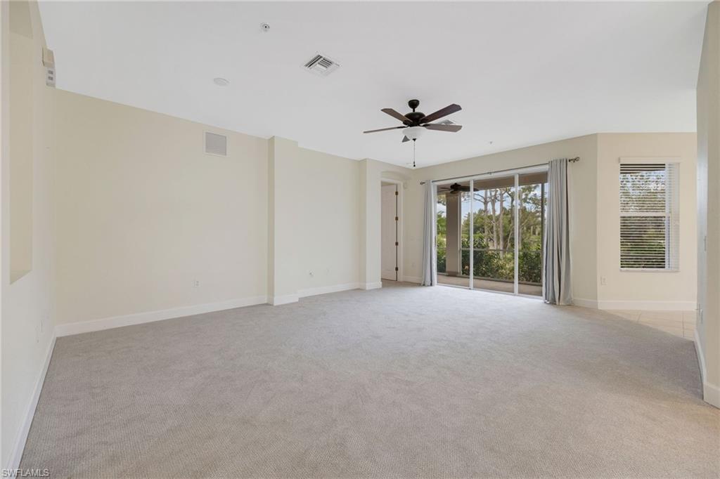 Carpeted spare room featuring ceiling fan