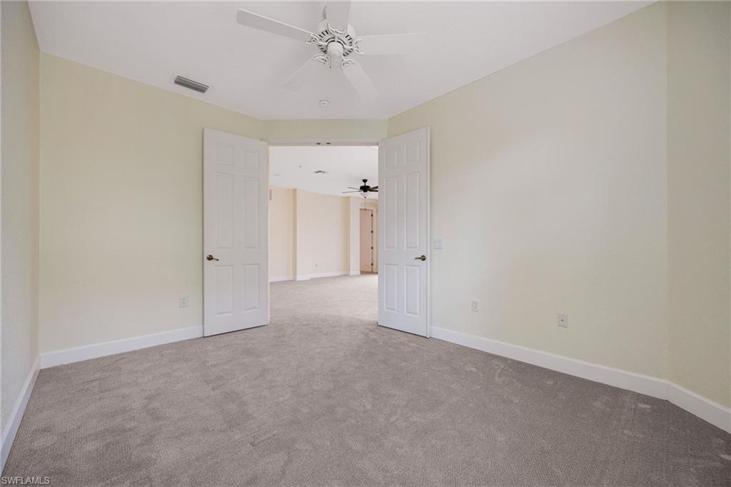 Empty room featuring ceiling fan and light colored carpet