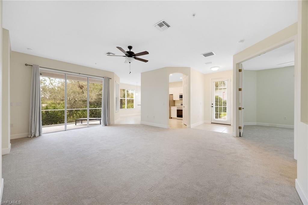 Unfurnished living room featuring ceiling fan and light carpet