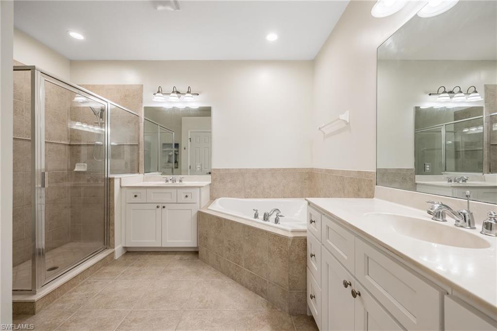 Bathroom featuring vanity, tile patterned floors, and separate shower and tub