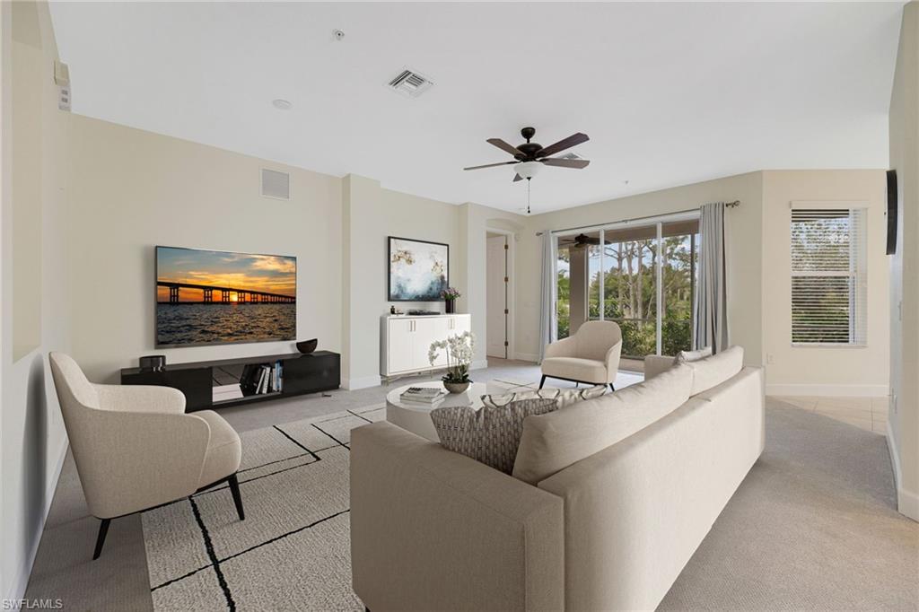 Living area featuring light colored carpet and a ceiling fan