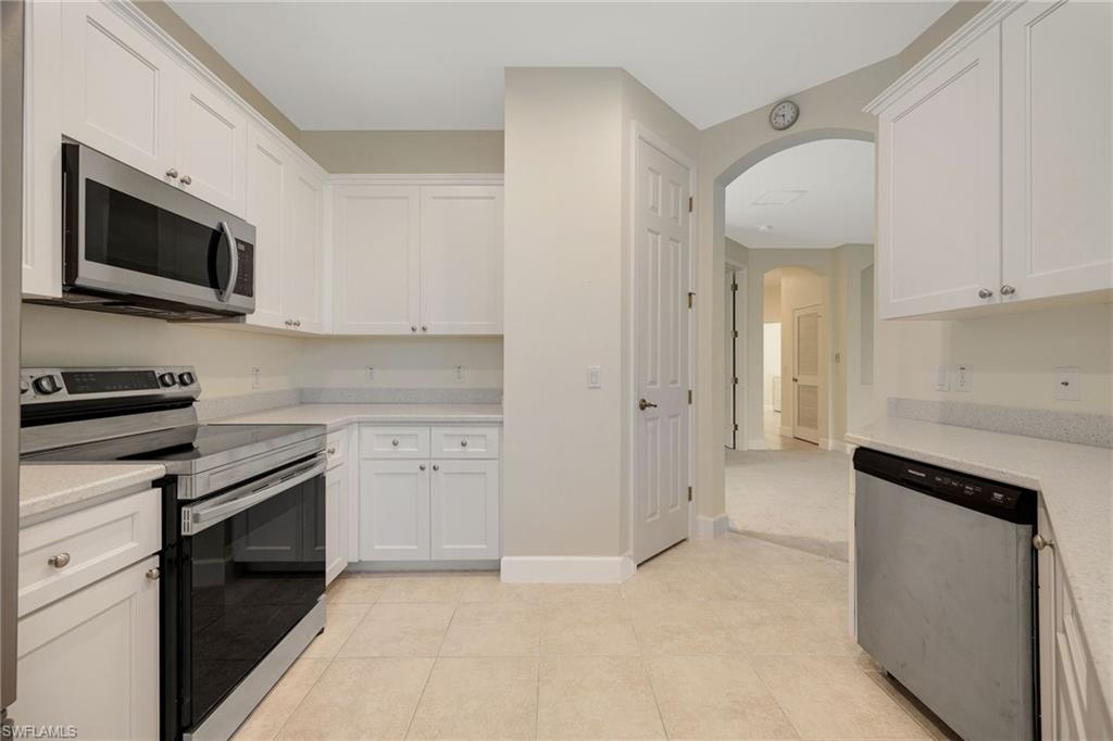 Kitchen with white cabinetry, appliances with stainless steel finishes, and light tile patterned flooring