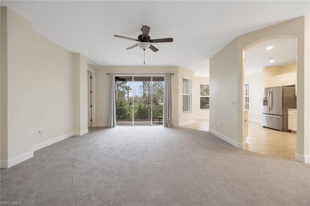 Unfurnished living room featuring light colored carpet and ceiling fan