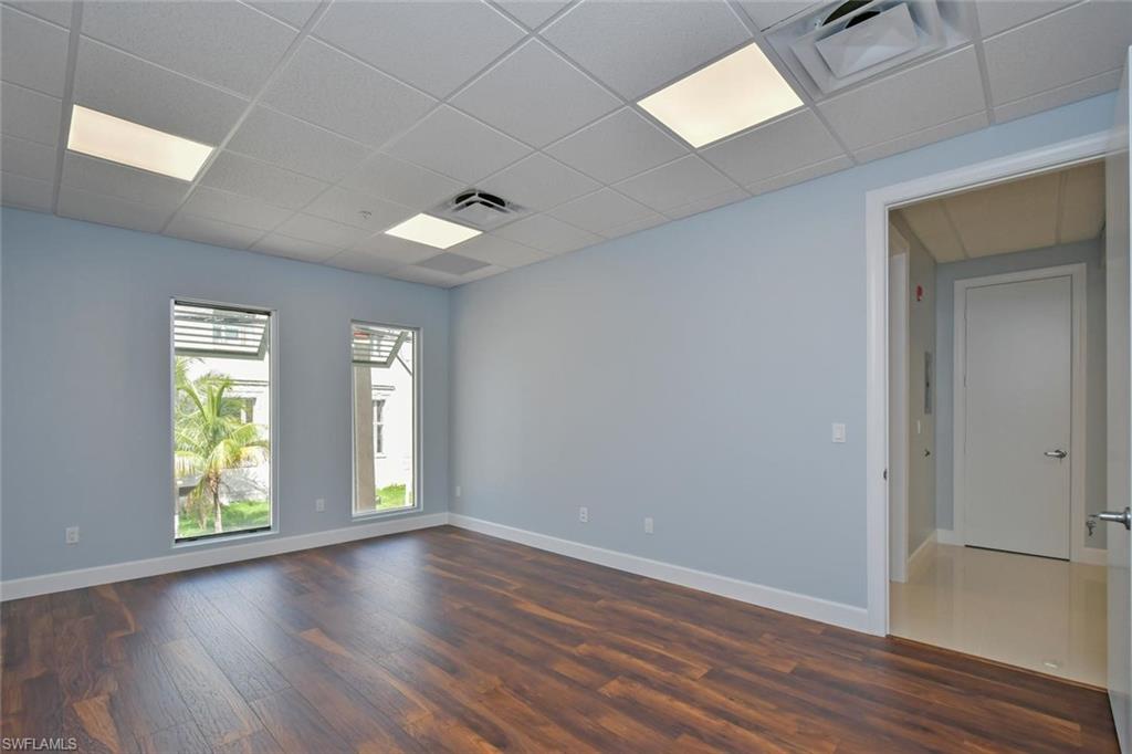 Empty room featuring a paneled ceiling and dark hardwood / wood-style floors