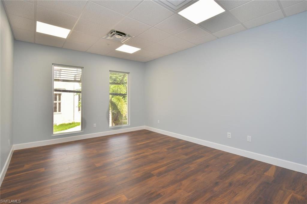 Unfurnished room with a paneled ceiling and dark hardwood / wood-style floors