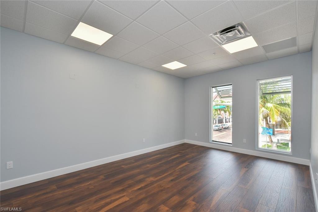 Empty room featuring a paneled ceiling and dark hardwood / wood-style floors