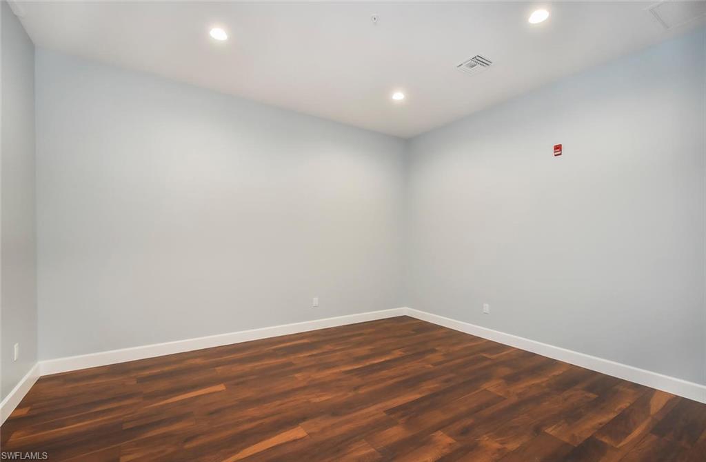 Empty room with dark hardwood / wood-style floors