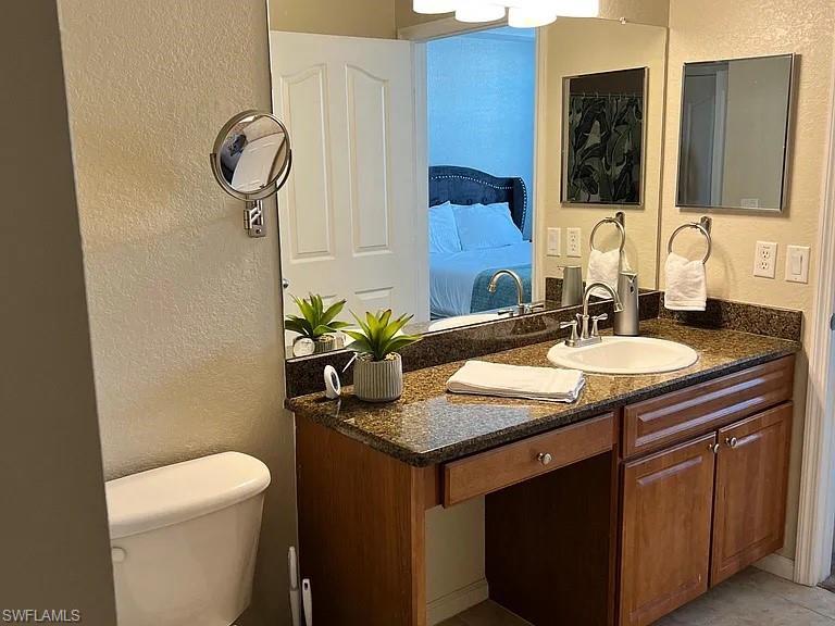 Bathroom with tile patterned flooring, vanity, and toilet