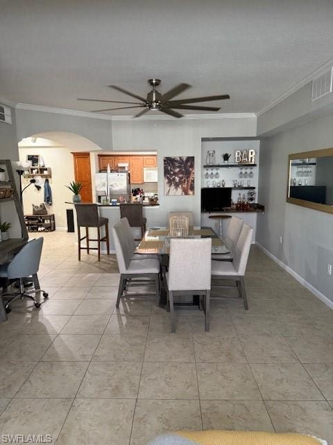 Dining space with light tile patterned flooring, ceiling fan, and ornamental molding