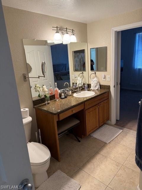 Bathroom with vanity, tile patterned flooring, a textured ceiling, and toilet