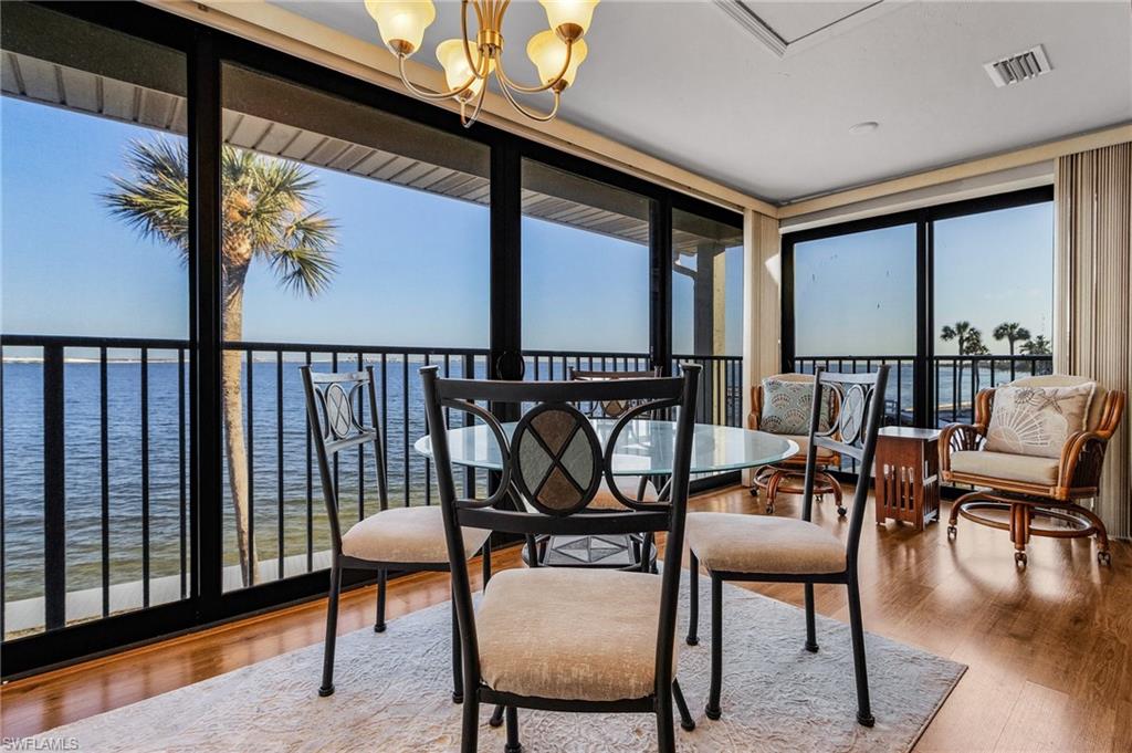 Sunroom / solarium with a notable chandelier and a water view