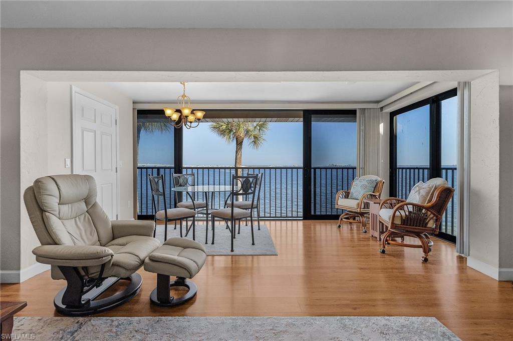 Living area featuring a notable chandelier, wood-type flooring, and a water view