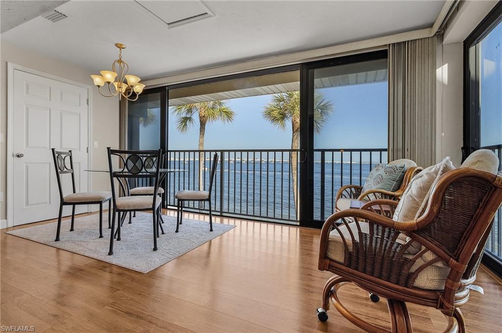 Sitting room featuring light hardwood / wood-style flooring, expansive windows, a notable chandelier, and a water view
