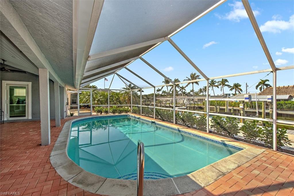 View of swimming pool featuring a lanai and a patio area