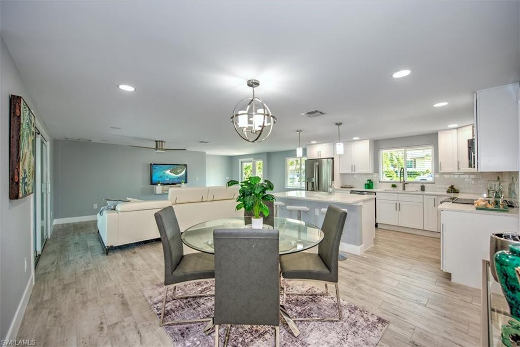 Dining room featuring ceiling fan with notable chandelier, light hardwood / wood-style flooring, and sink