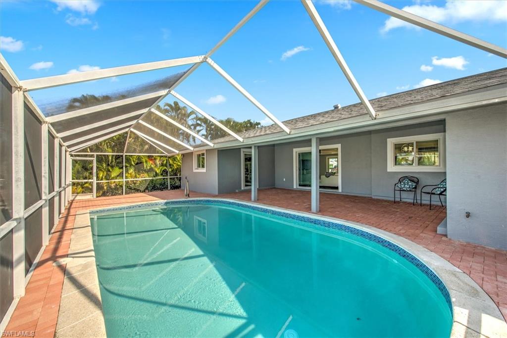 View of pool featuring a patio area and glass enclosure